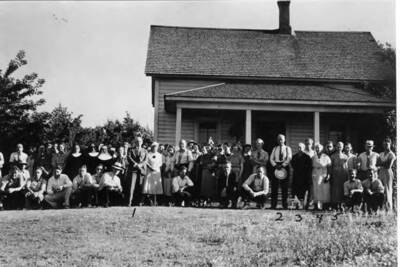 Pioneer home of the Cameron sisters, consisting of Annie, Margaret, and Alexandria Cameron, who are shown standing to the right of the entrance. The sisters have lived here continuously for the past 50 years. Their comfortable farmhouse is situated on an eminence overlooking an area of brilliant green slopes in the direction of the city of Moscow. About half-mile down the valley from the Cameron home, running in a general east and west direction, is the famous camas grounds of the Nez Perces. Indians gathered for the annual camas harvest here every year about June 15. The camas was to the Indian what the wheat or potato crop was to the white man. To the Indian, camas was wheat and flour and bread. The camas fields in Tat-kin-mah, the place of the spotted deer, as the Indians called modern Moscow areas, was a noted camas ground. The camas plant, a species of the lily (onion) family, is found only in flood plains and mountain meadows of the Rocky Mountain region and westward. It is, therefore, entirely Western American. No. 2- On Map. About two miles south and one mile east of South Main Street on the west side of Paradise Ridge Road. No. 1- Dr. C.J. Brosnan, No. 2- George M. Tomer, No. 3-4-5- Cameron sisters. Picture 1937. [C.J. Brosnan may have written this text.]