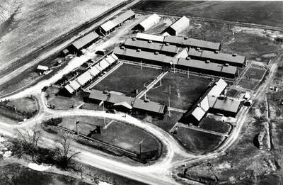 Looking northeast at the Civilian Conservation Corps 1503 camp from the air. Highway 95 foreground, South Palouse [River?] left. Picture after July 2, 1938 [90-0131] and before April 1939 [90-0131] pictures. Note small pond between the two willow trees in foreground.