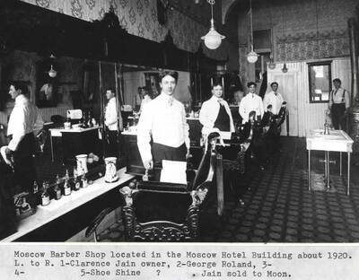 Located in the Hotel Moscow building about 1920. Left to right: 1- Clarence Jain, owner. 2- George Roland. 3- 4- 5- shoe shine ?. Jain sold to Moon.