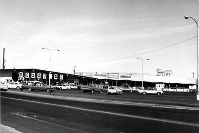 West of Main Street at Rosauer's, Drug Fair, and Checker Auto Parts. This location formerly occupied by the Idaho National Harvester Company. Picture by Clifford M. Ott August 14, 1977.