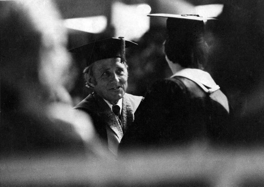 A distance photograph of University of Idaho President Ernest W. Hartung congratulating a graduate.