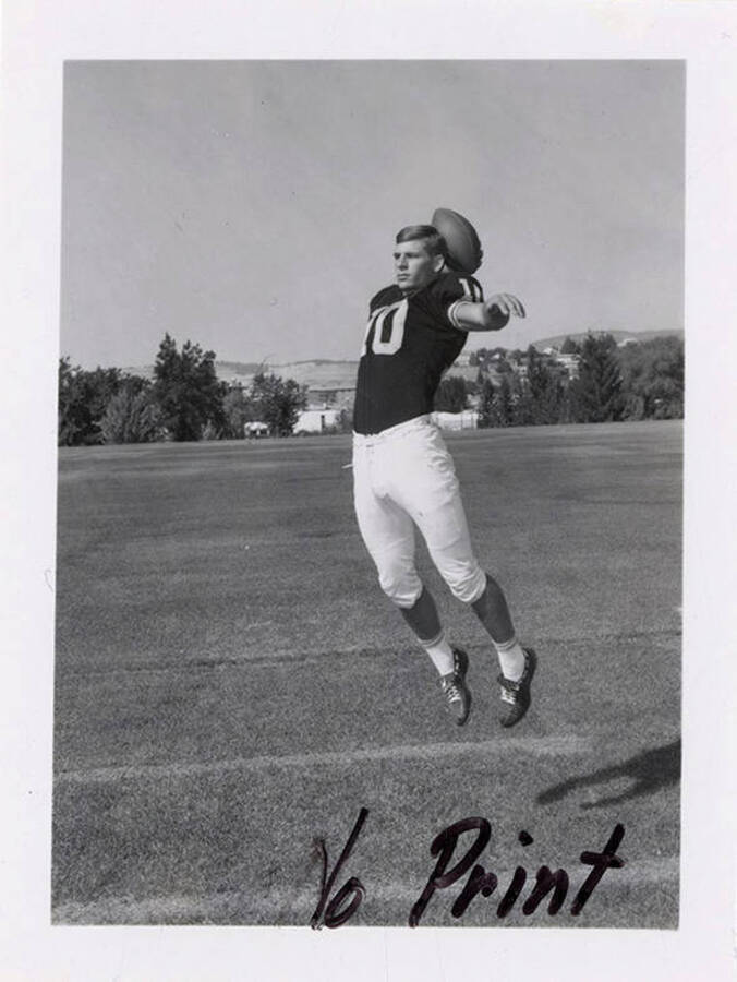 Jim Wickboldt, a defensive back for the University of Idaho, jumping in preparation to throw a football.