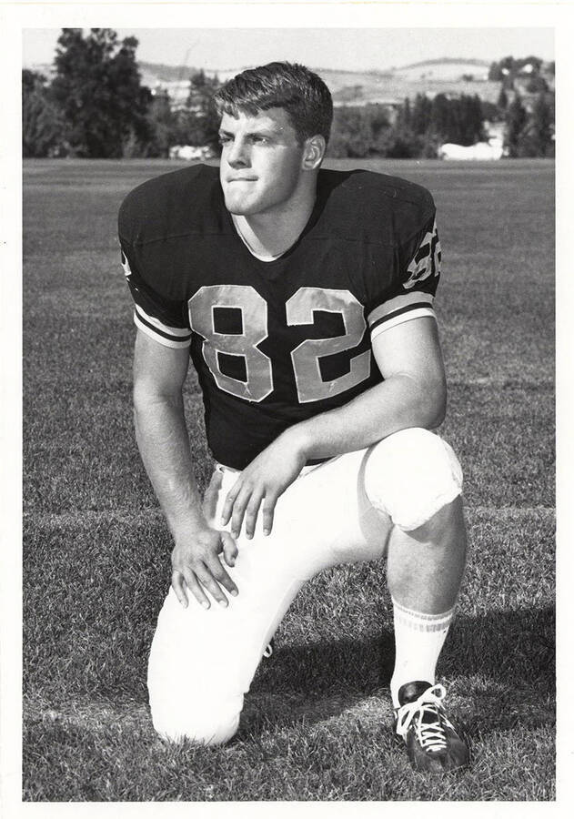 Wing back for the University of Idaho, Doug Whidden, kneeling while looking off into the distance.