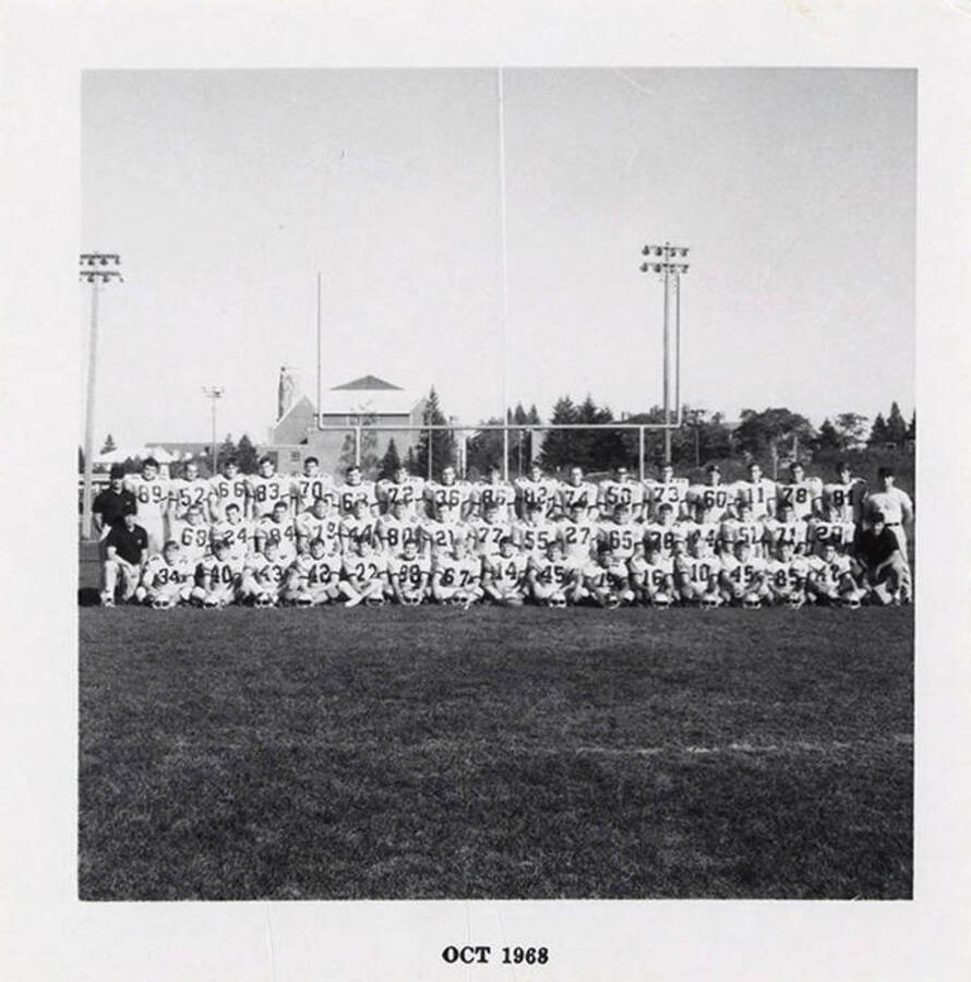 A group photo of the Vandal freshman football team wearing their white jerseys in front of the goal post.