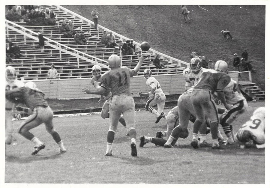Steve Olson (#11) throwing the ball to a teammate during a football game.
