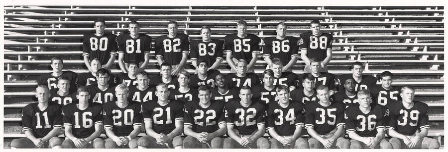 A group photo of the Vandal freshman football team wearing their black jerseys on the bleachers.