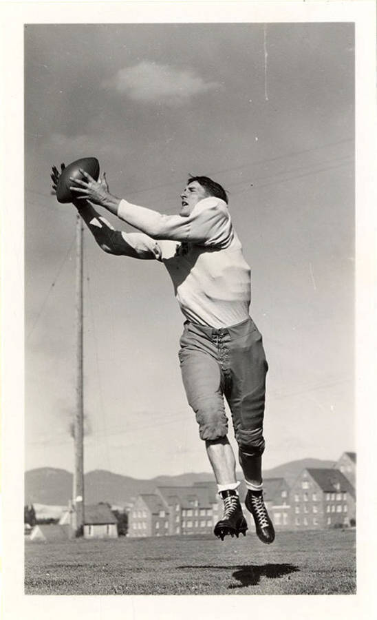Emory Howard, an end for the University of Idaho football team, catching a football mid-air.