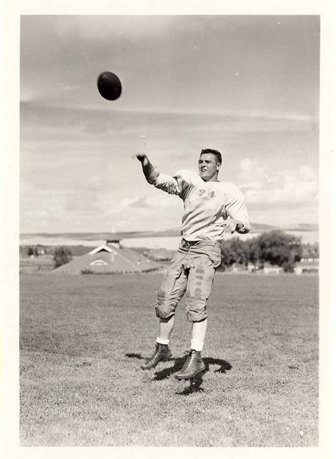Right halfback Earl Acuff for the University of Idaho, mid-air after throwing the football.