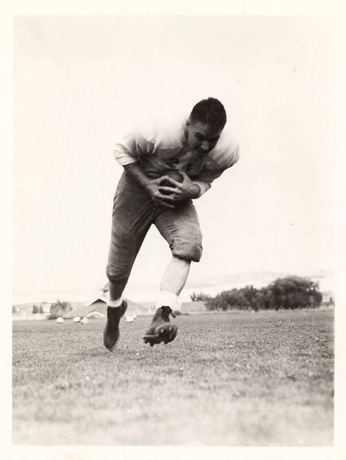 Right halfback Earl Acuff for the University of Idaho, running with the football