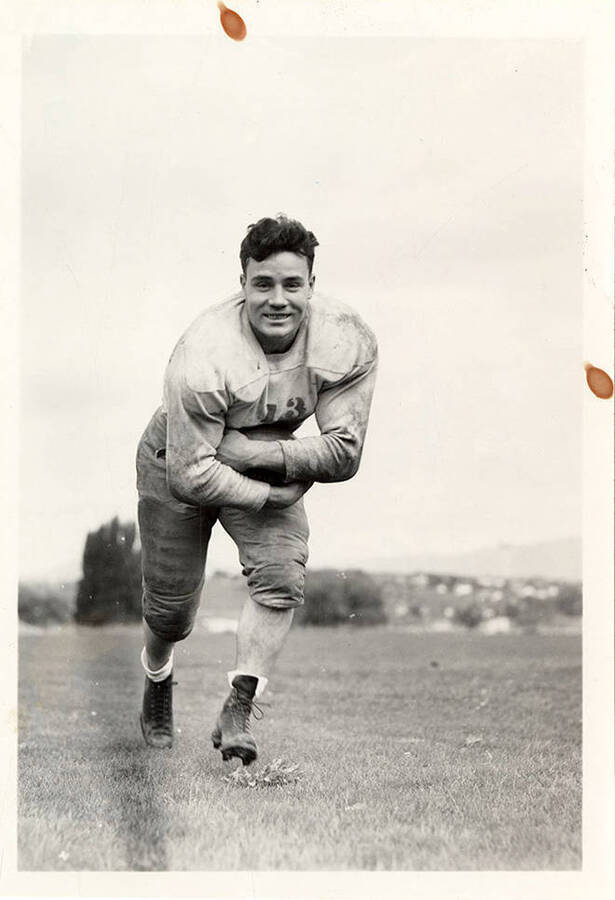 LaVern Bell, a football player for the University of Idaho, smiling and running with the football.