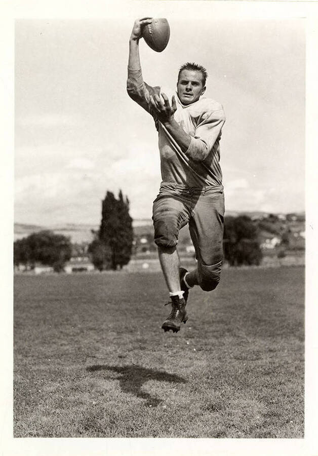 Veto Berllus, right end for the University of Idaho football team, catching a football mid-air.