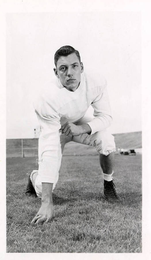 Freshman football player for the University of Idaho, Ron Chase, crouching on the field.