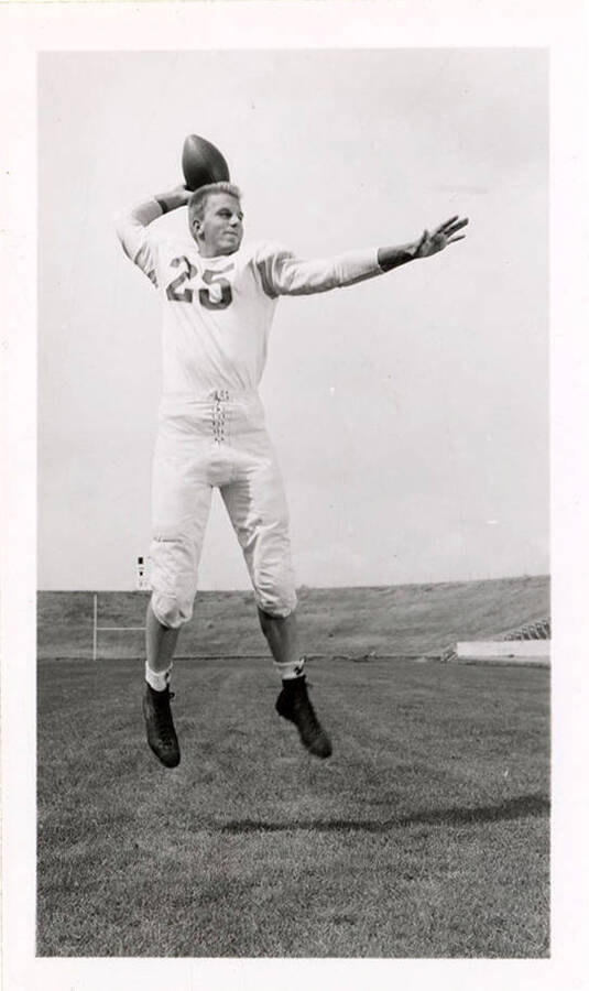 George Eidam (#25), a freshman football player for the University of Idaho, mid-air as he throws a football.