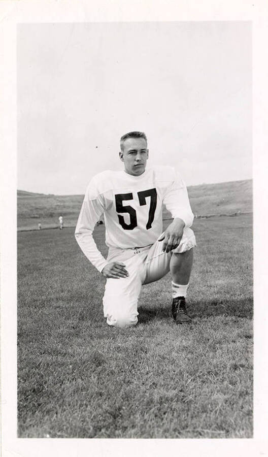 Roger Randolph, a freshman on the University of Idaho football team, kneeling on the field.