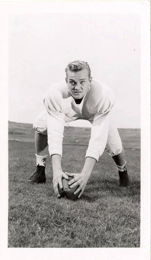 Freshman University of Idaho football player, Tony Tardiff, crouching with two hands on a football.