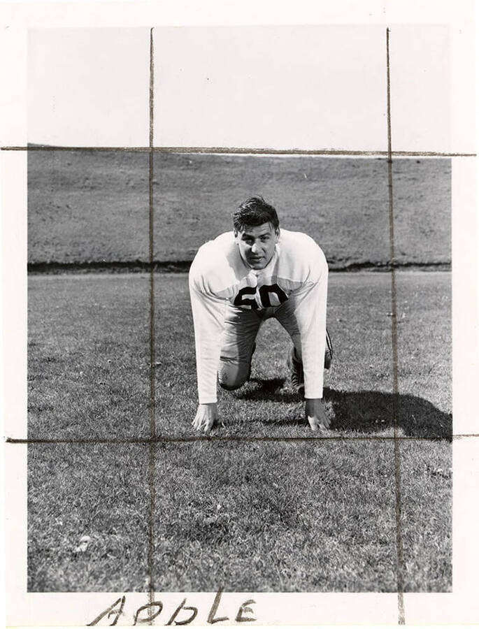 Football player Len Apple (#50) crouching on the University of Idaho football field.