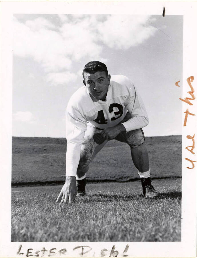 Guard for the University of Idaho football team, Lester Diehl (#43) crouching with a hand on the football field. 'Use this' and, 'Lester Diehl,' are written on the photograph.