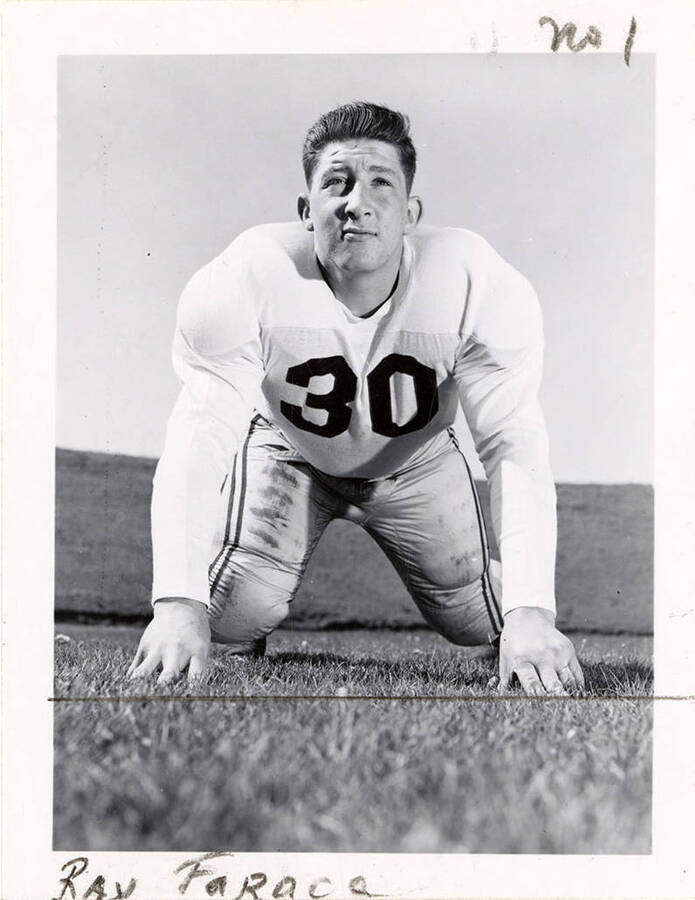 Football player, Ray Faraca (#30), a guard for the University of Idaho, kneeling on the football field.