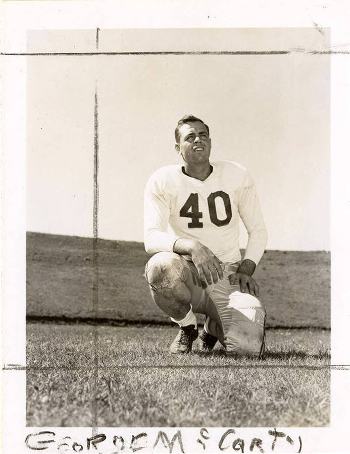 George McCarty (#40), tackle for the University of Idaho football team, kneeling on the football field.