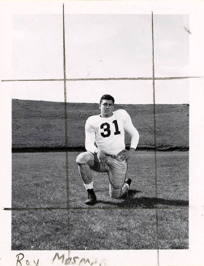 Football player for the University of Idaho, Roy Mosman (#31) kneeling on the football field.
