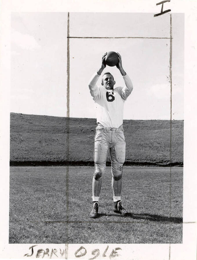 Jerry Ogle (#6), an end for the University of Idaho football team, catching a football on the field.