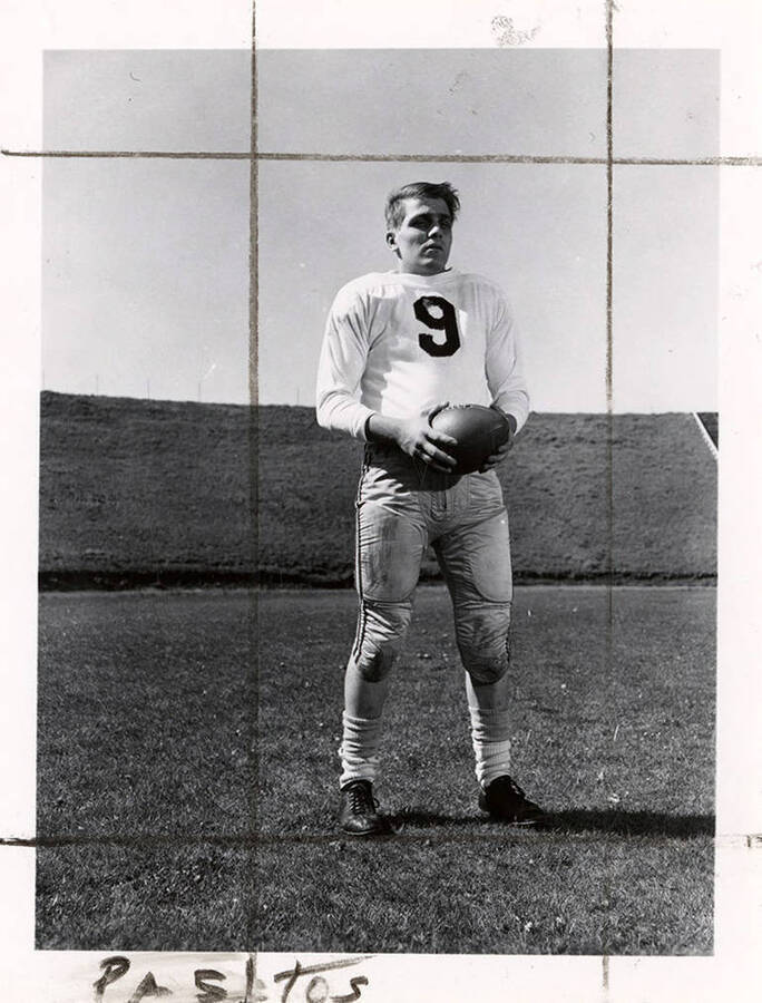 Football player for the University of Idaho, Gus Pastos (#9), standing on the field with a football.