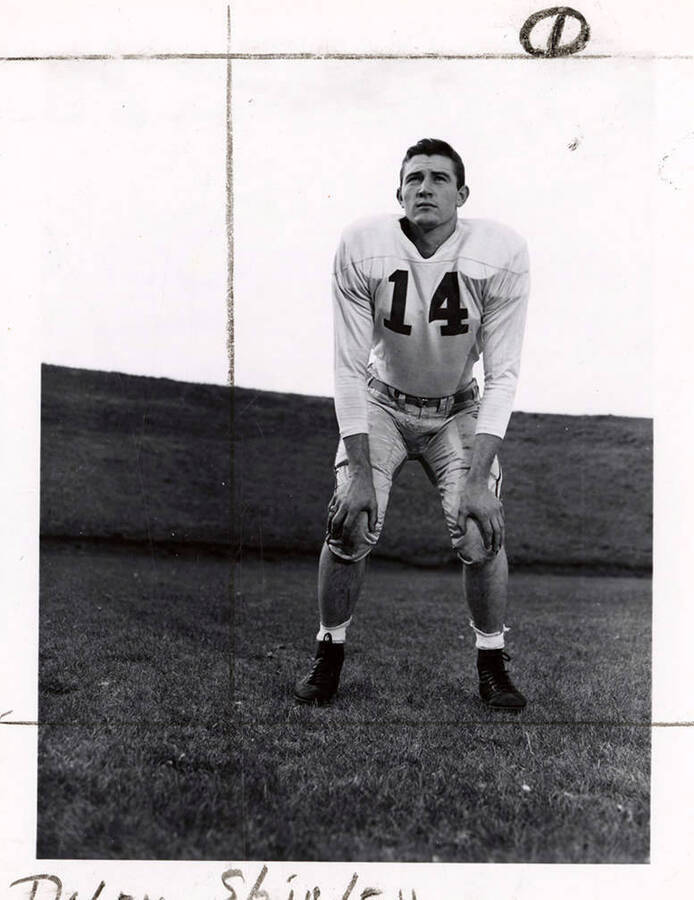 Fullback for the University of Idaho football team, Dalby Shirley (#14) resting with his hands on his knees on the football field.