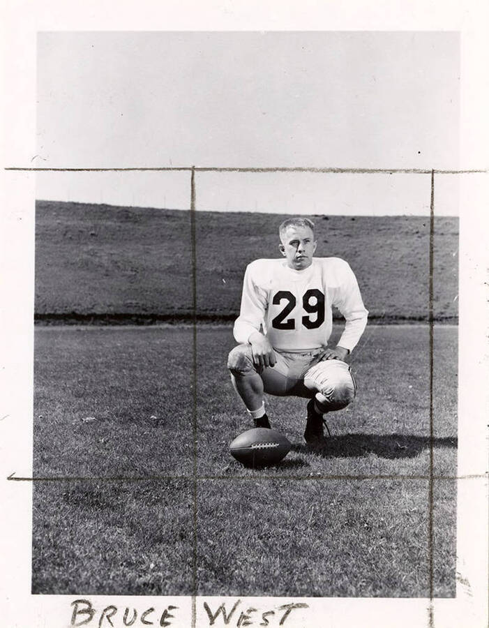 Bruce West (#29), a player for the University of Idaho football team, on the field with a football.