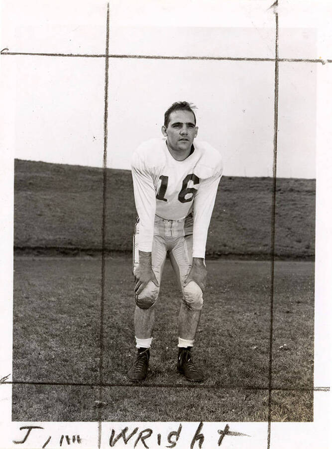 Football player for the University for Idaho, Jim Wright (#16), standing with his hands on his knees.
