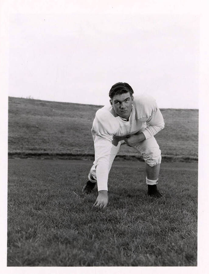 John Armitage, tackle for the University of Idaho football team, crouching on the football field.
