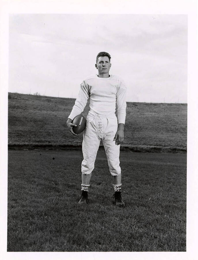 Halfback for the University of Idaho football team, Ted Frostenson standing on the football field.