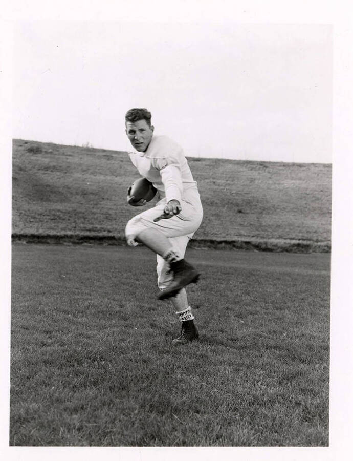 Halfback for the University of Idaho football team, Ted Frostenson running on the football field.
