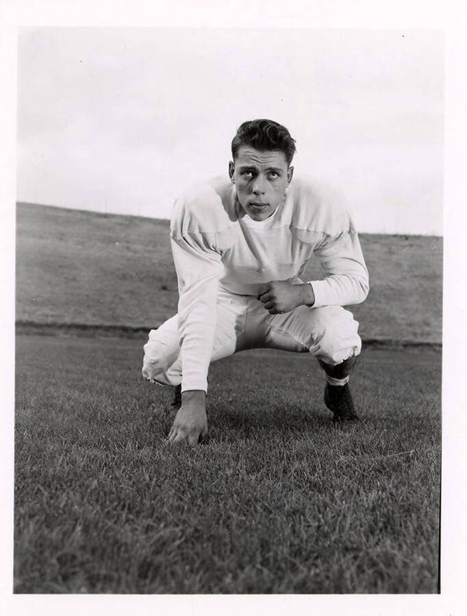 Burchard Roard, a tackle player for the University of Idaho, crouching on the field.