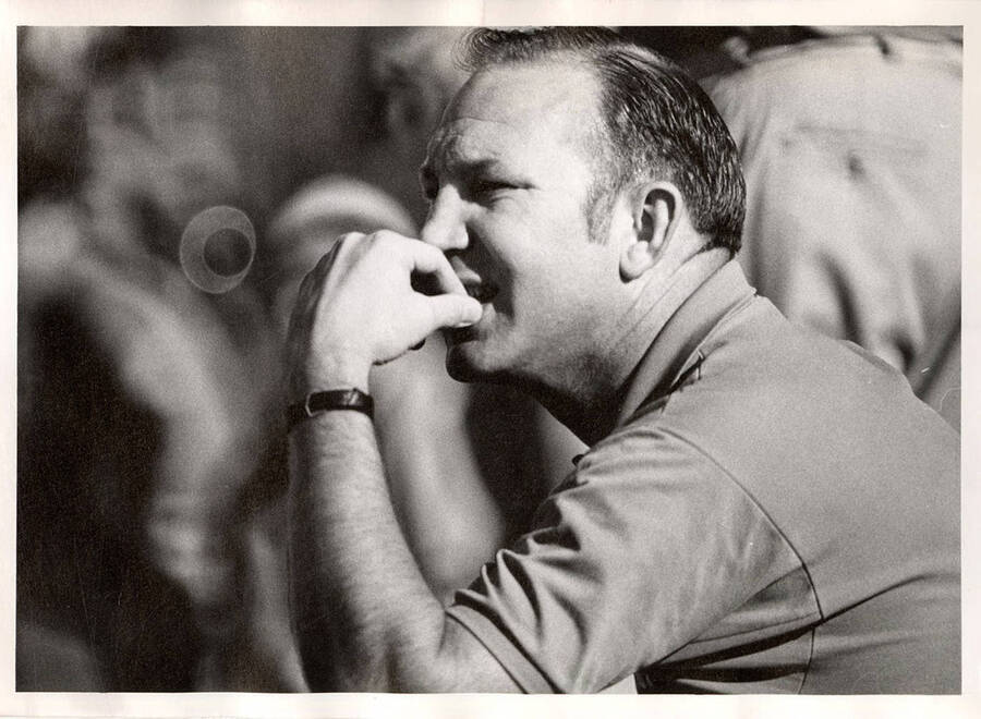 A coach bites his nails in anticipation on the sidelines during a University of Idaho football game.