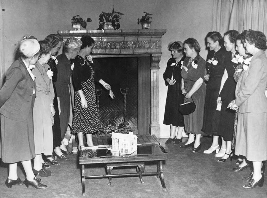 Women gather to examine the fireplace in the Kappa Alpha Theta house during the Kappa Alpha Theta reunion.