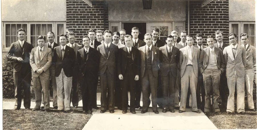 Blue Key members stand in front of an unidentified building for a group photograph. Blue Key is a national upperclassmen's honorary fraternity.