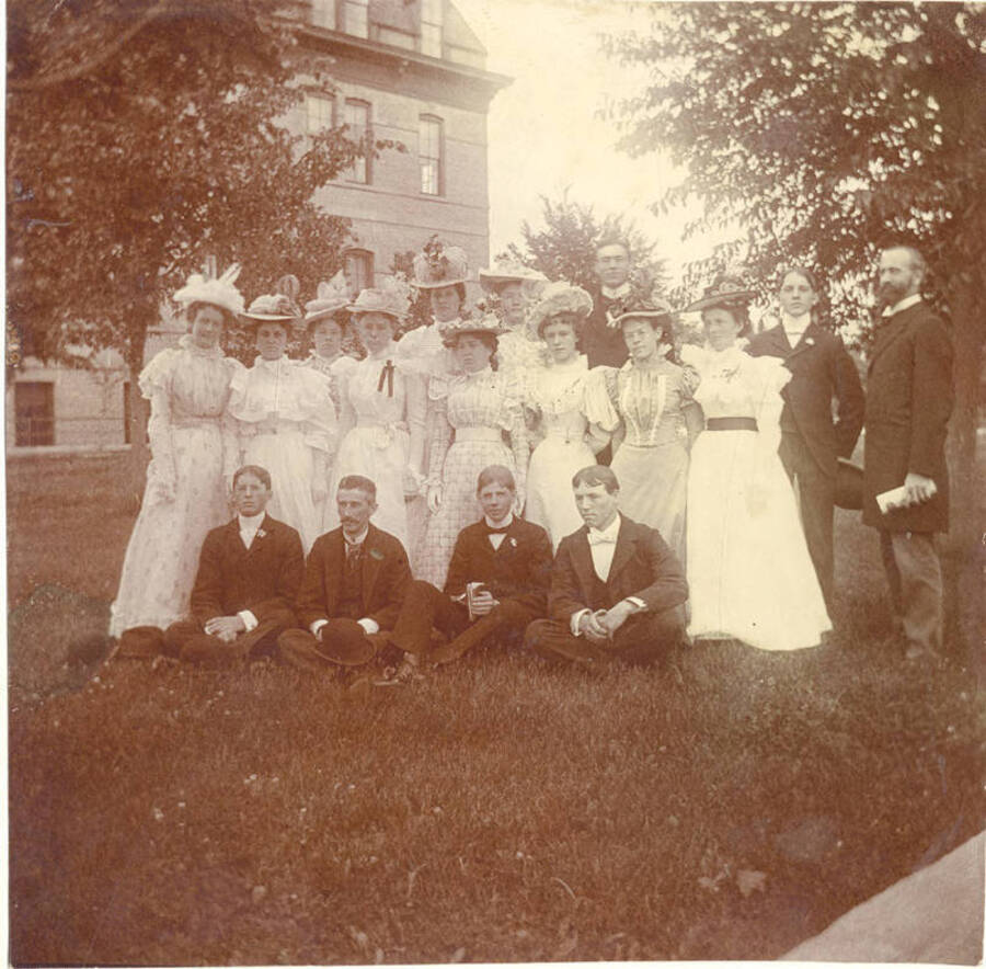 Students of the class of 1910 stand together for a photo. On the back of the photograph is written: 'With congradulations and best wishes for you my classmate. Ida Himrod?'