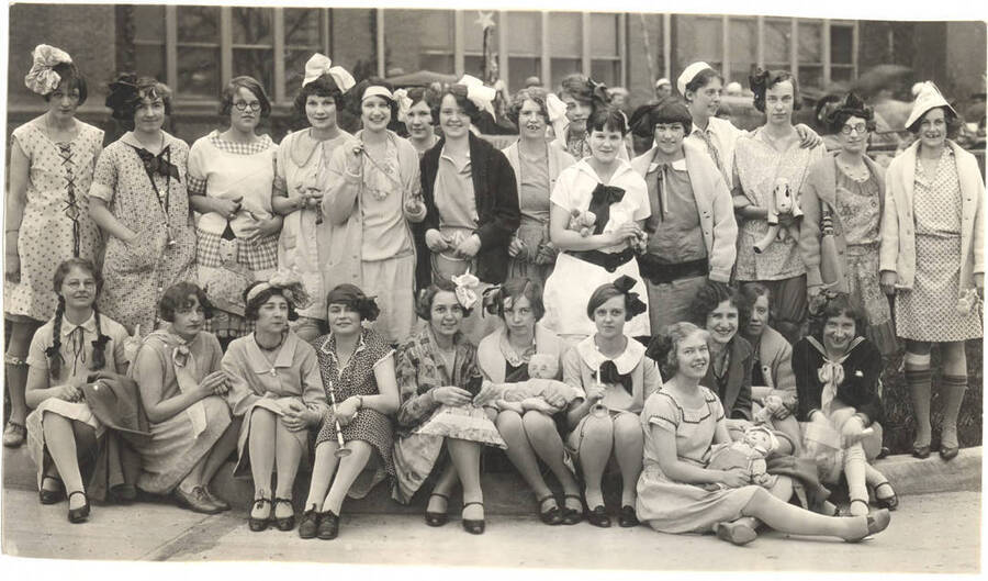 Women of Ridenbaugh Hall are dressed for a Kid's Party as part of a parade in front of the Administration Building.