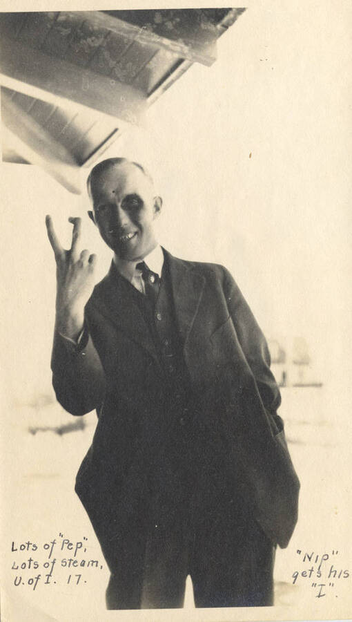Arthur H. Neilson makes a hand gesture with two-fingers. Inscription: Lots of 'pep', Lots of steam, U of I 17. 'Nip gets his 'I''