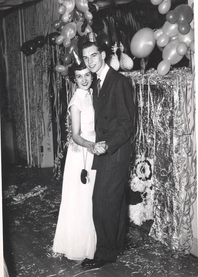 An unidentified greek couple poses for a photograph at a formal-themed event.