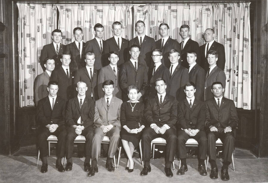 Members of the Beta Theta Pi fraternity pose for a group photo with their House Mother Mrs. Cummins in their house.