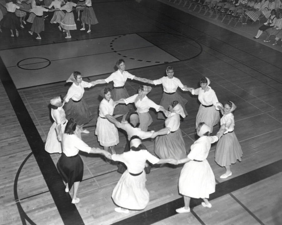 A group of women dance in a circle together during the folk dance festival.