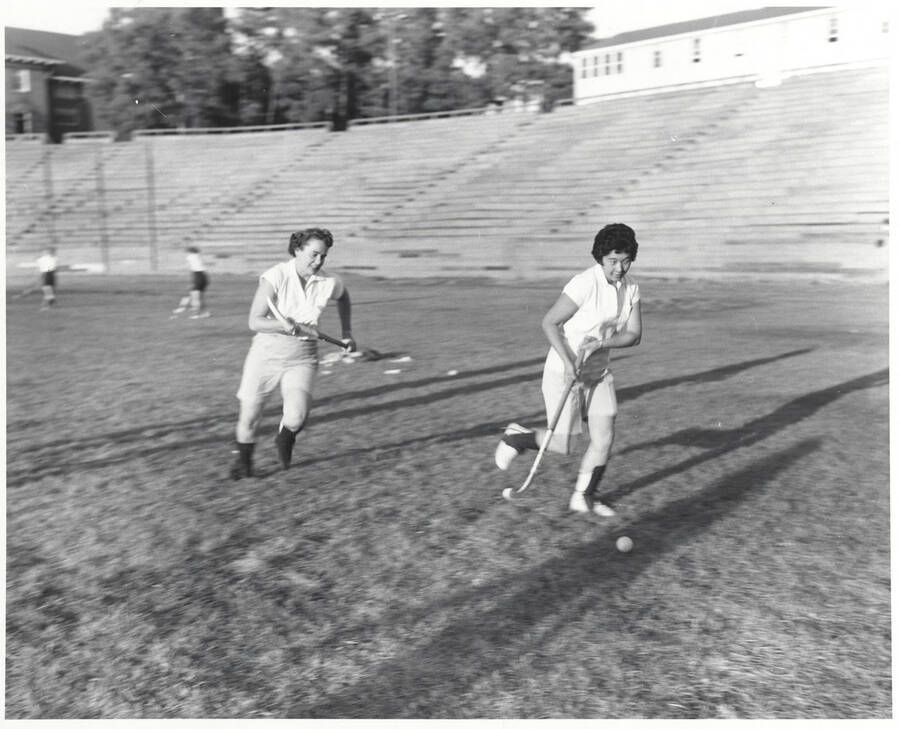 Two women go for the ball during field hockey pracitce on MacLean Field.