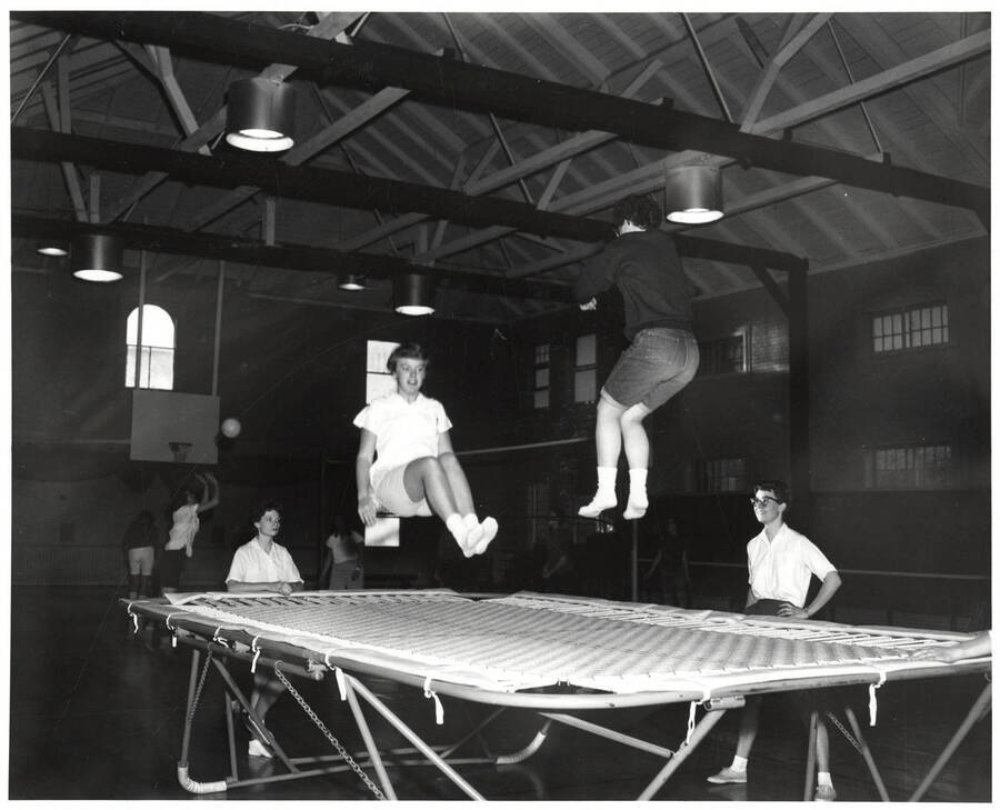 Two women jump on a trampoline in the Women's Gymnasium with the Women's Recreation Association.