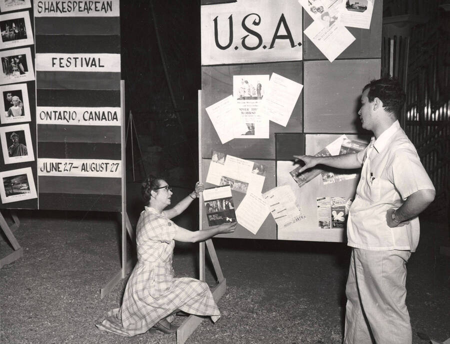 Directors Jean Collette and Edmund Chavez take time out from rehearsals to arrange posters and signs on a flat during Summer Theatre at the University of Idaho.
