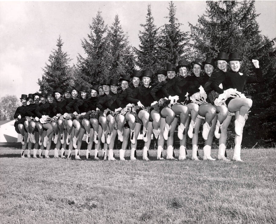 Vandalettes pose for a group photograph in passe in a line formation while wearing their uniforms.
