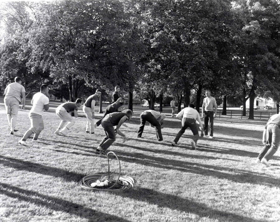 Men starting a play in an intramural touch football game on the Administration lawn.
