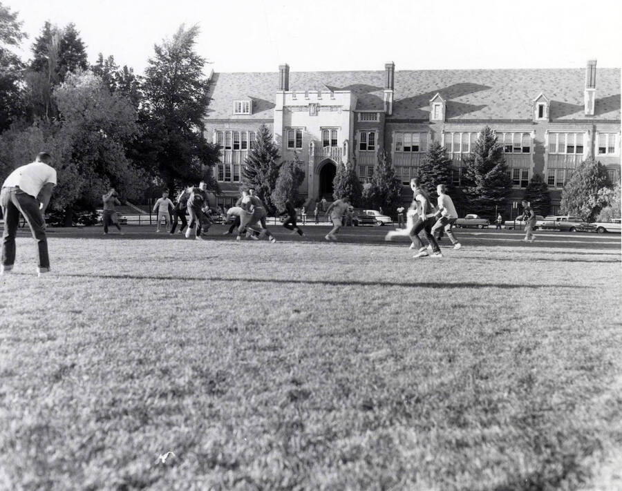 Men playing intramural touch football on the Administration lawn.