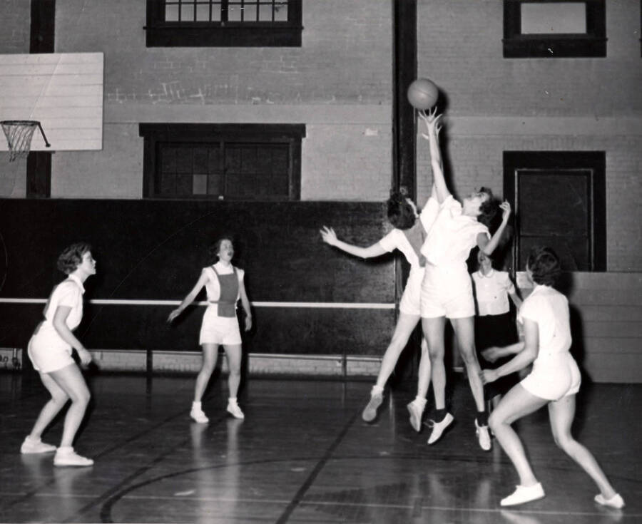Two women go for the tip off during an intramural basketball game.