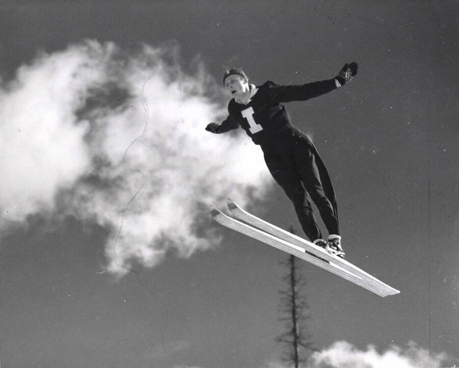 An unidentified skier jumps with his arms spread out.